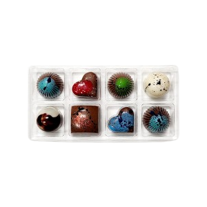 Assorted chocolate bonbons in a decorative box on a white background