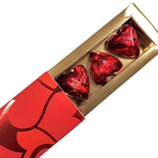 Red heart-shaped chocolate bars in a gold box on a white background
