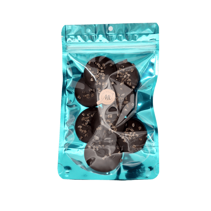 Cyan stand-up pouch with 8 dark chocolate disks topped with cocoa nibs
